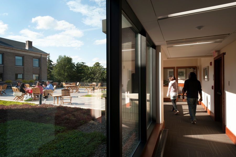 group meeting on rooftop terrace and people walking in hallway